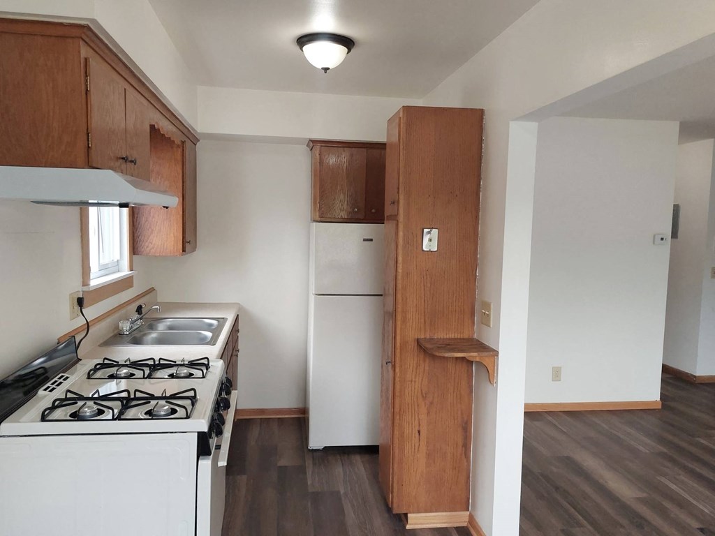 an empty kitchen with a stove and a refrigerator