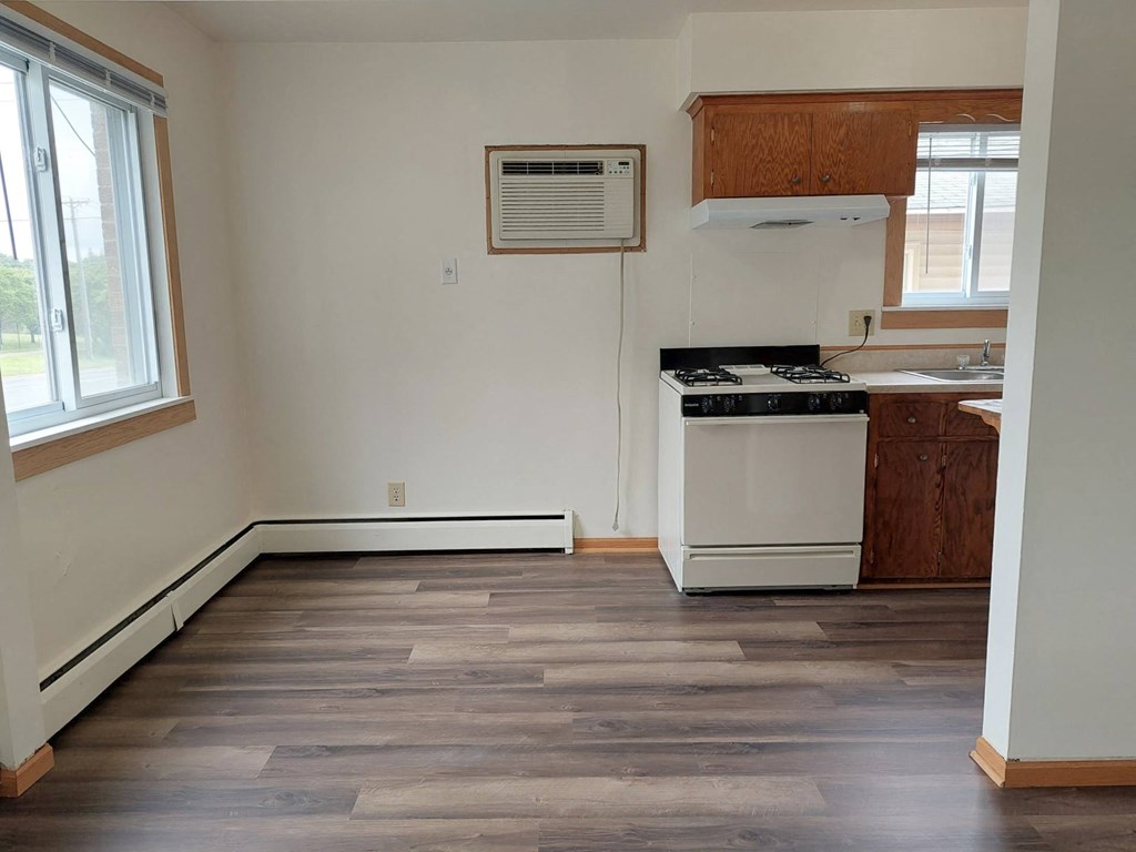 an empty kitchen with a stove and a window