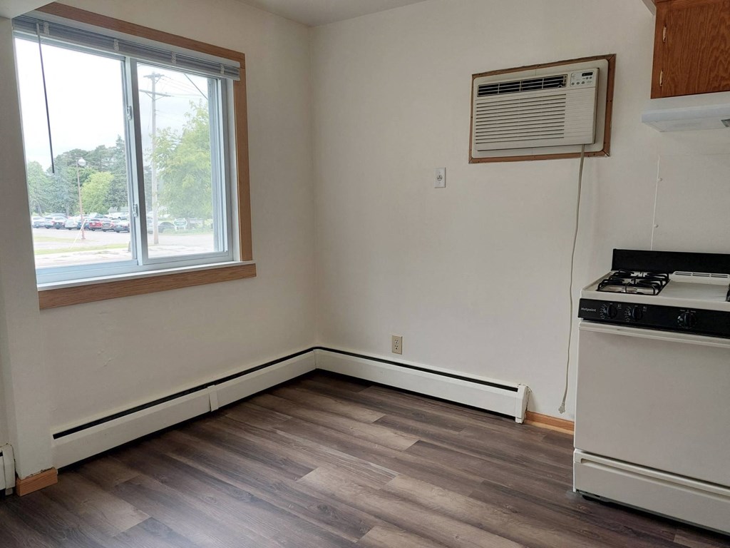 an empty room with a stove and a window