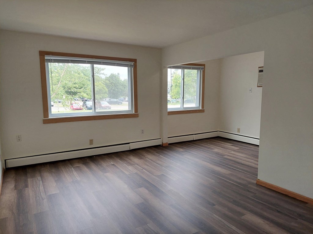 a living room with wood floors and a large window