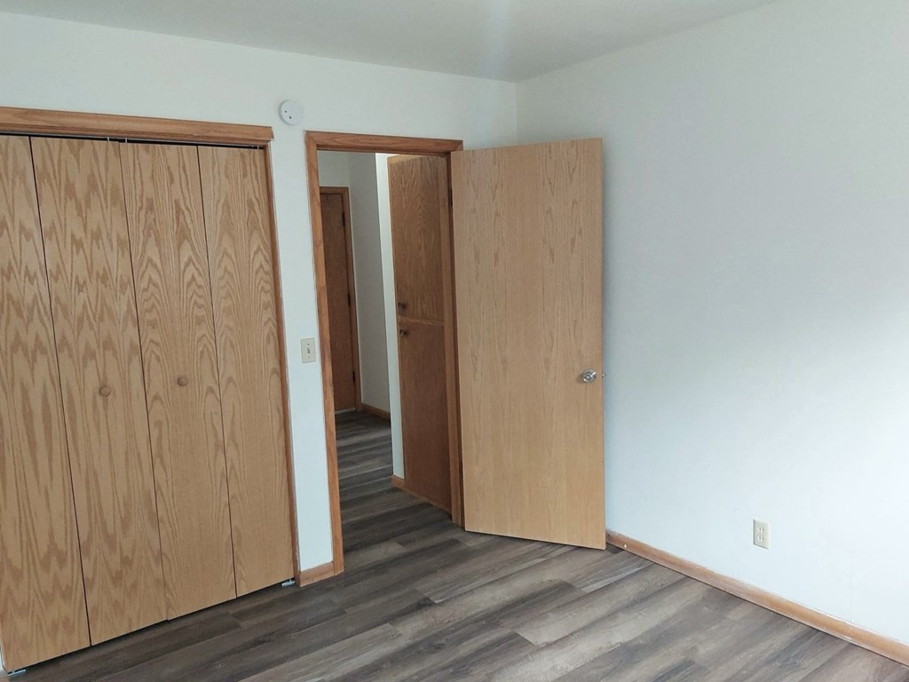 an empty room with two doors and a door to a closet