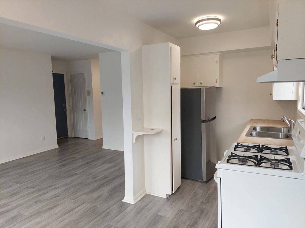 a kitchen and living room with a stove and refrigerator