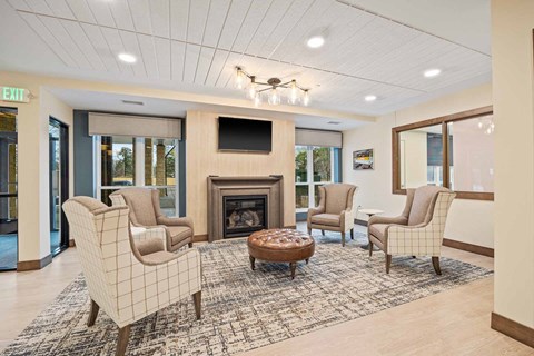 A living room with a fireplace and chairs.