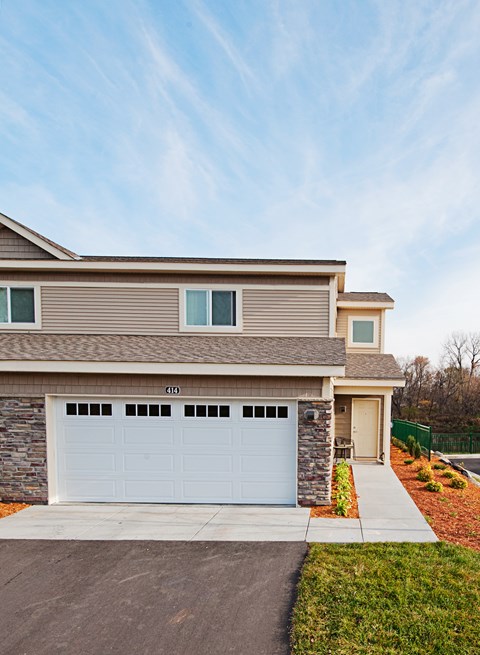 A house with a white garage door is numbered 411.