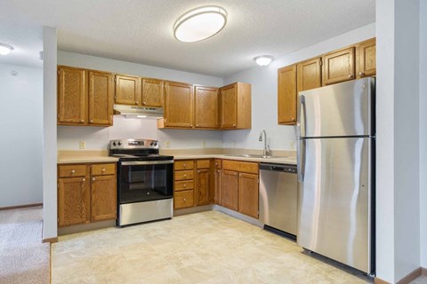 A kitchen with wooden cabinets and stainless steel appliances.