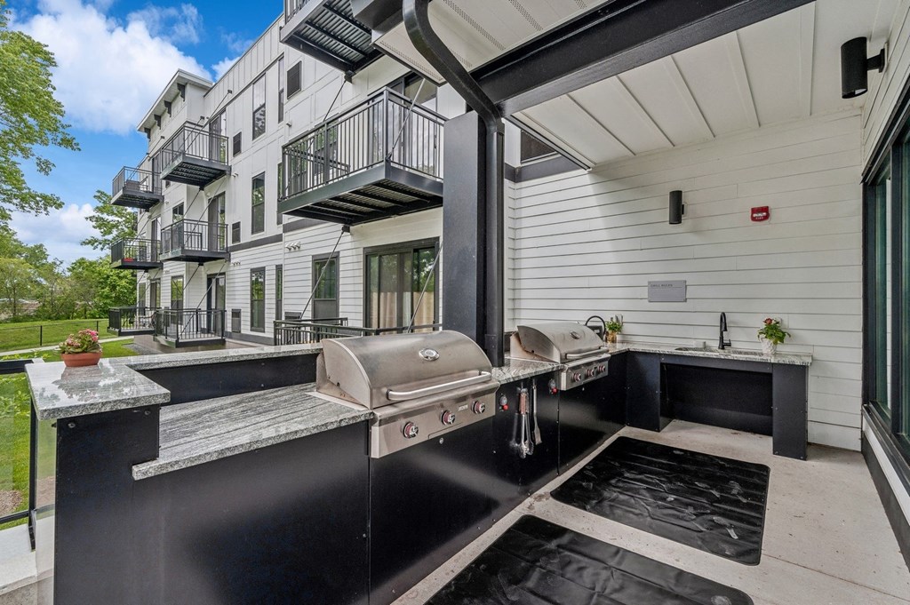a large outdoor kitchen with a grill and a sink