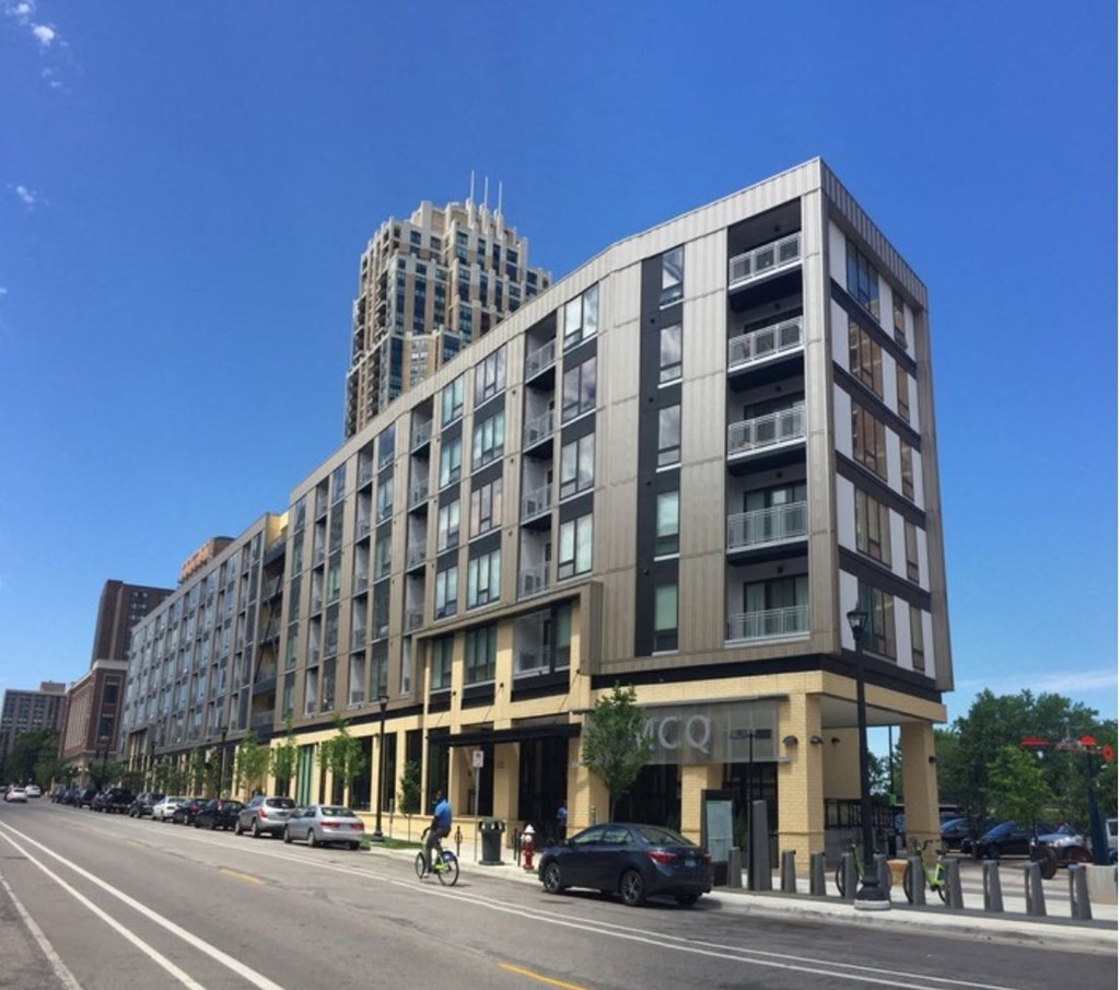 a large building with a tower in the background and a person on a bike in the foreground