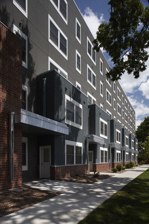 a large apartment building with a sidewalk in front of it