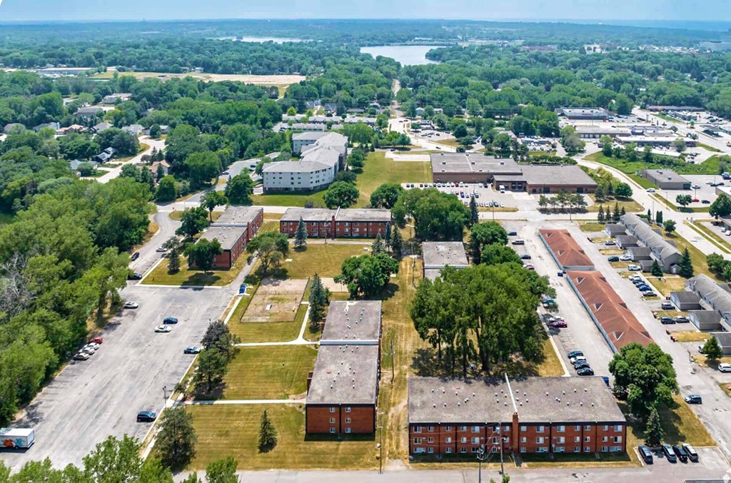 A bird's eye view of a campus with buildings, trees, and a parking lot.