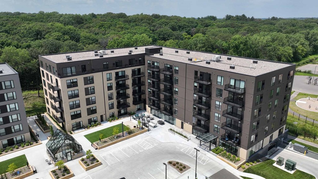 an aerial view of an apartment complex with trees in the background