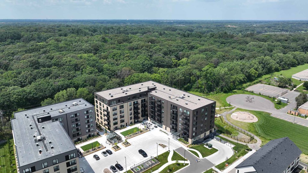 an aerial view of three apartment buildings and a parking lot