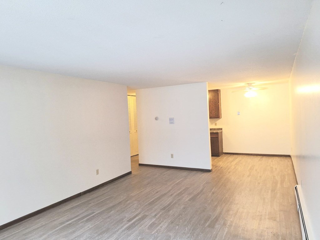 an empty living room with white walls and wood flooring