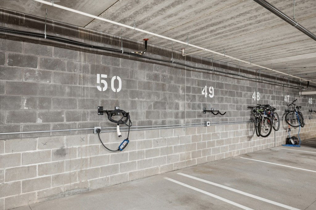 a parking garage with bikes hanging on the wall