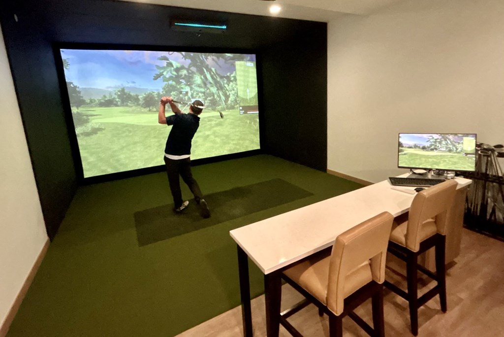 a man playing a video game in a room with a table and a tv
