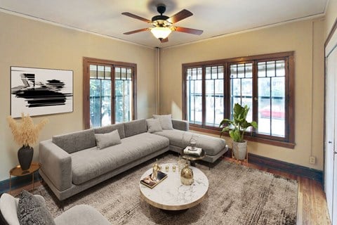 a living room with a gray couch and a ceiling fan