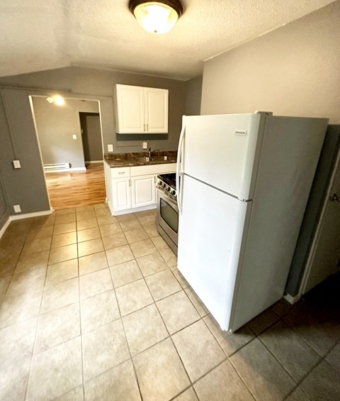 a kitchen with a refrigerator and a stove in it