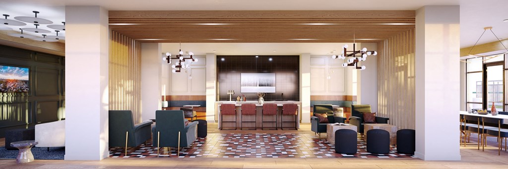 a lounge area with tables and chairs and a kitchen in the background