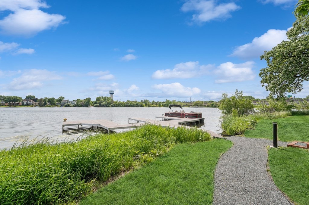 a path next to a river with a boat on it