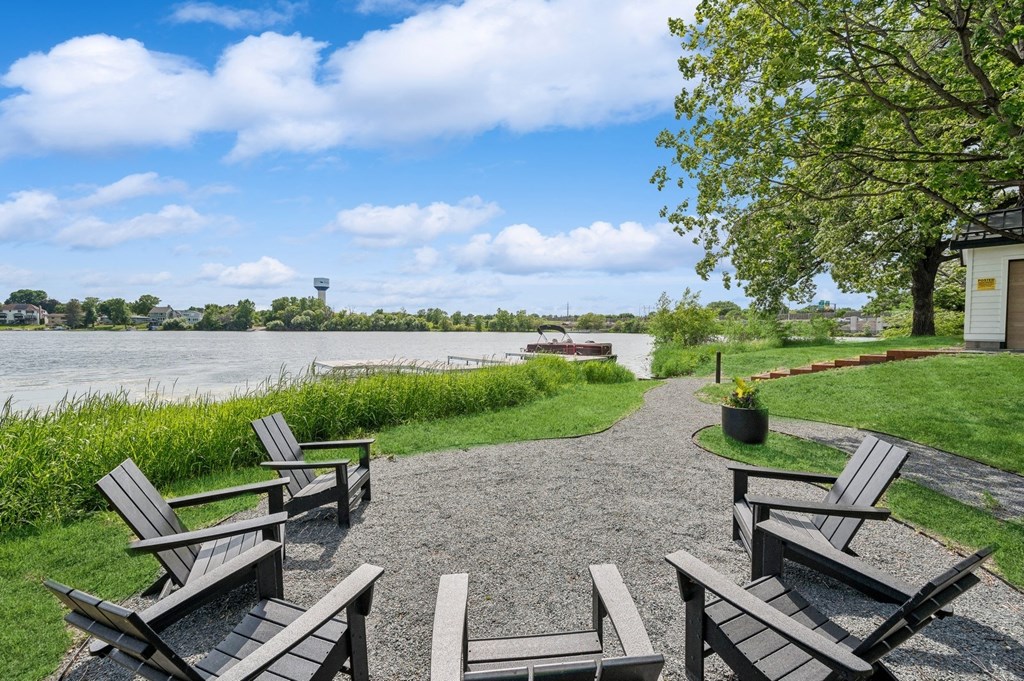 a park with benches and a river in the background