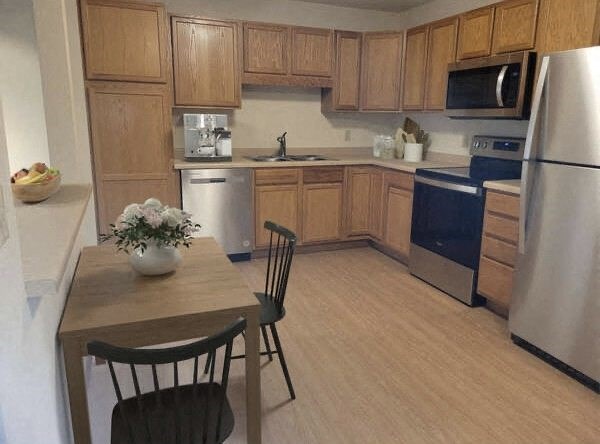 a kitchen with wooden cabinets and a table and chairs