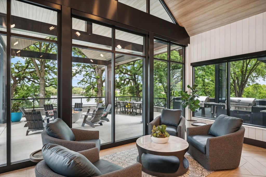 a living room with chairs and a table in front of glass doors