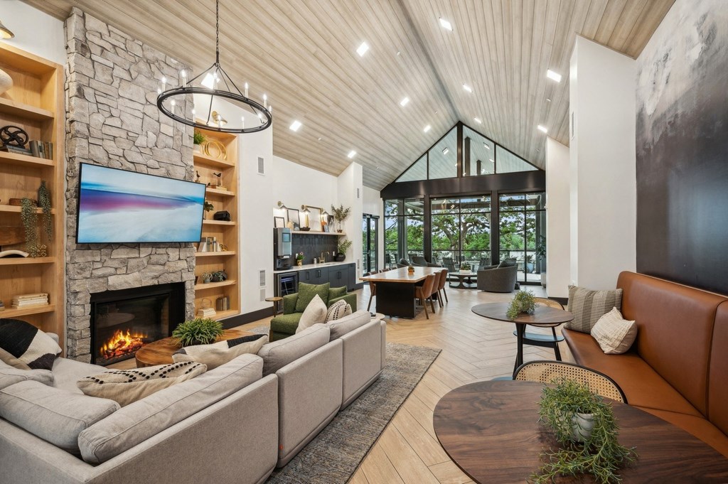 the living room has a stone fireplace and a tv on the wall