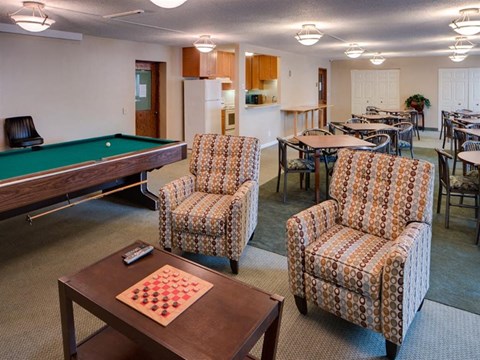 a living room filled with furniture and a pool table