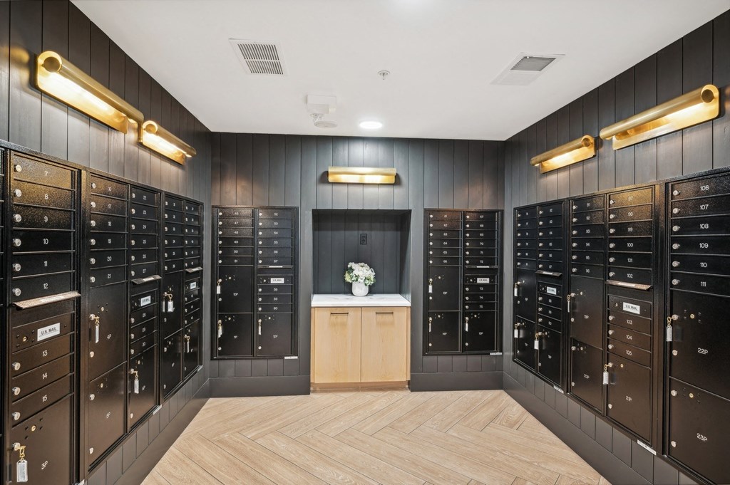 a lockers room with wooden floors and black cabinets with gold lights