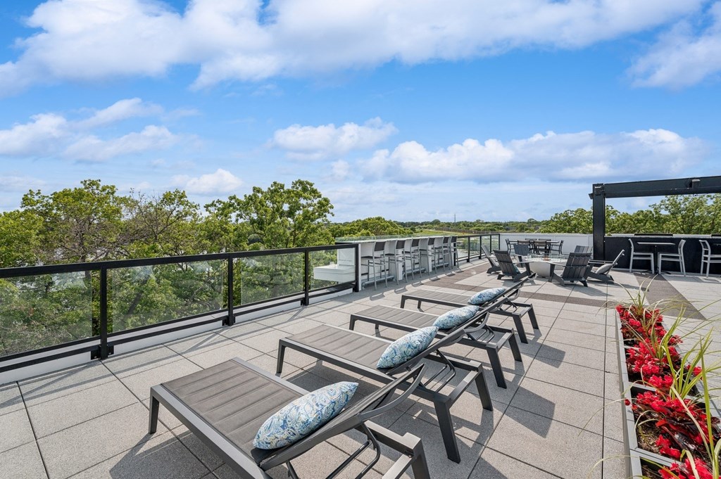 a patio with tables and chairs on top of a roof