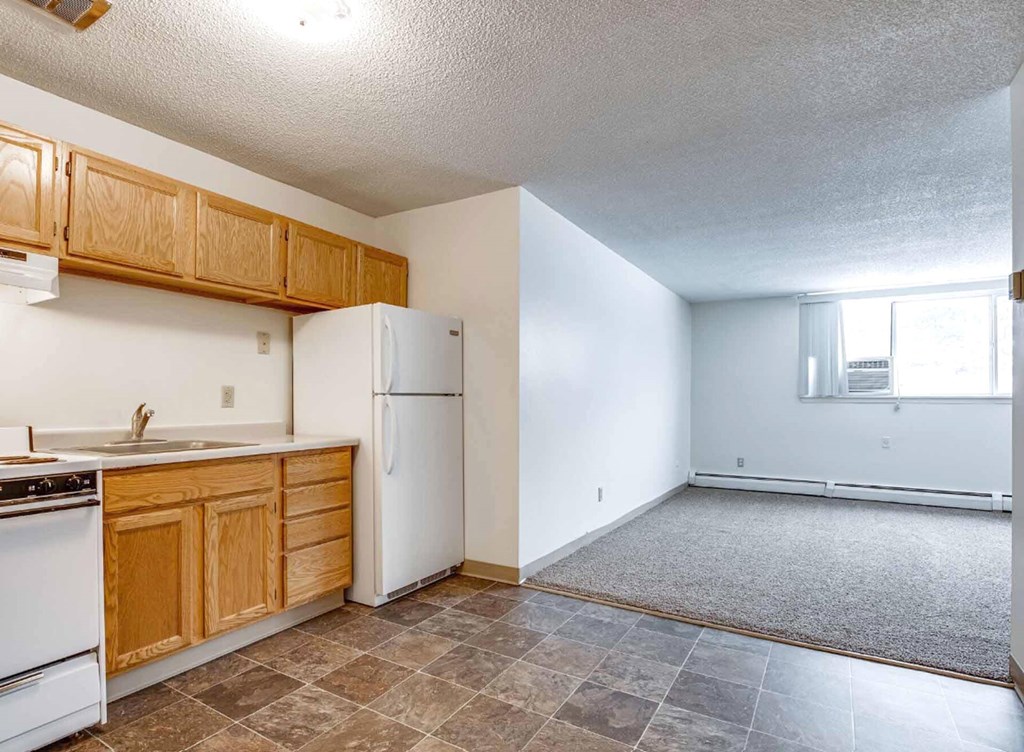 A kitchen with white appliances and wooden cabinets.