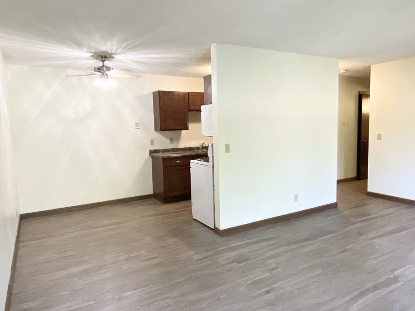 Twin Lakes Living Room an empty living room with a white refrigerator freezer next to a stove top oven
