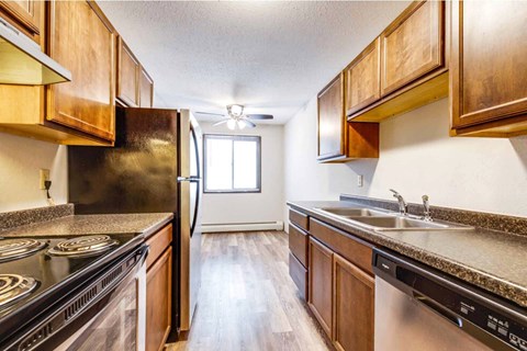 a kitchen with wooden cabinets and a sink and a refrigerator