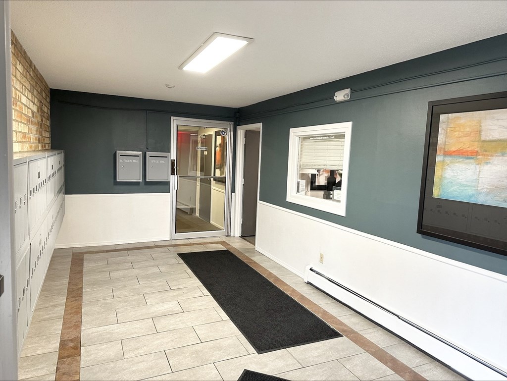 a hallway with a tile floor and blue and white walls