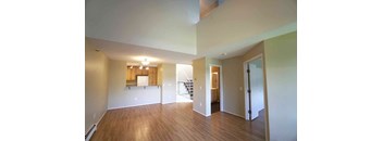 7602 York empty living room with wood flooring and a kitchen