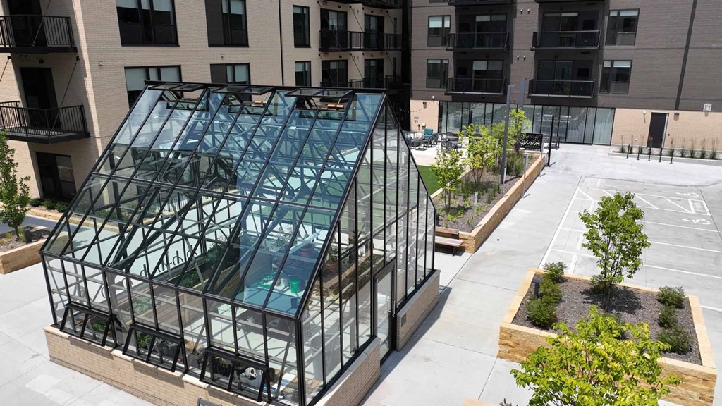 an aerial view of a building with a glass facade and a courtyard