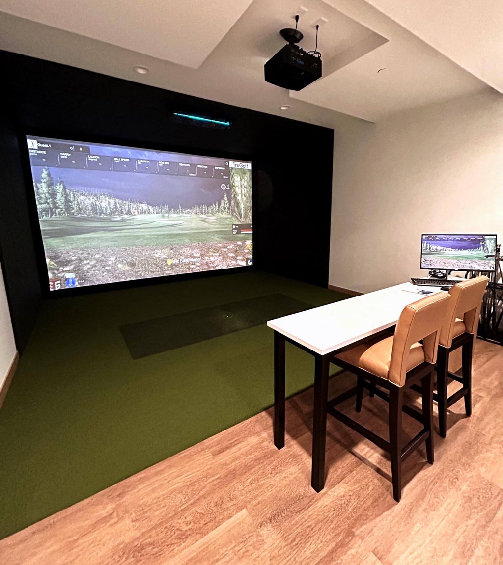 a room with a table and chairs and a large screen