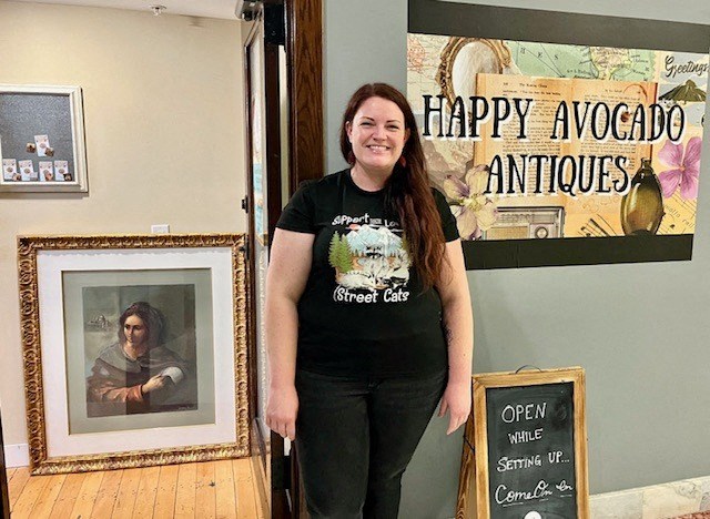 a woman in a black shirt standing in front of a picture