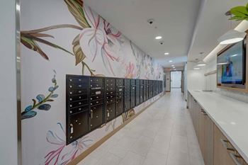 a long wall of mailboxes in a hallway with a floral wallpaper