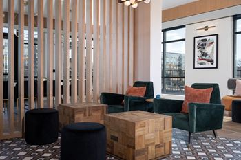 a lounge area with chairs and tables and a window