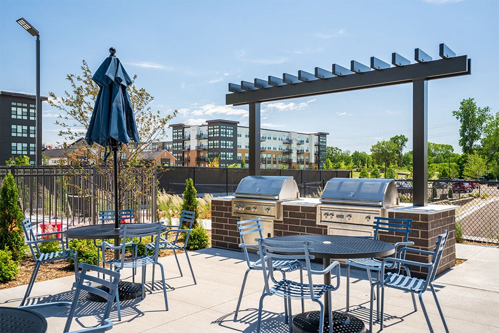 a patio with tables and chairs and an umbrella