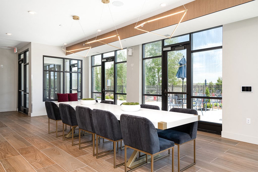 a dining room with a table and chairs and windows