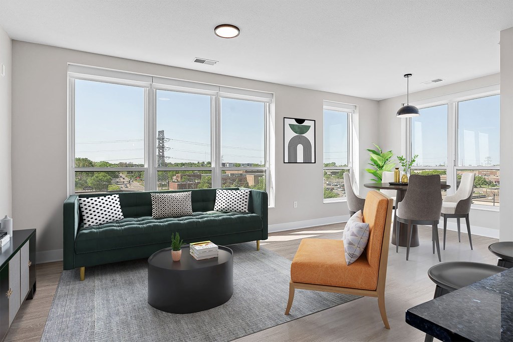 a living room with a green couch and a dining room table