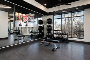 a home gym with a large window and a tv on the wall
