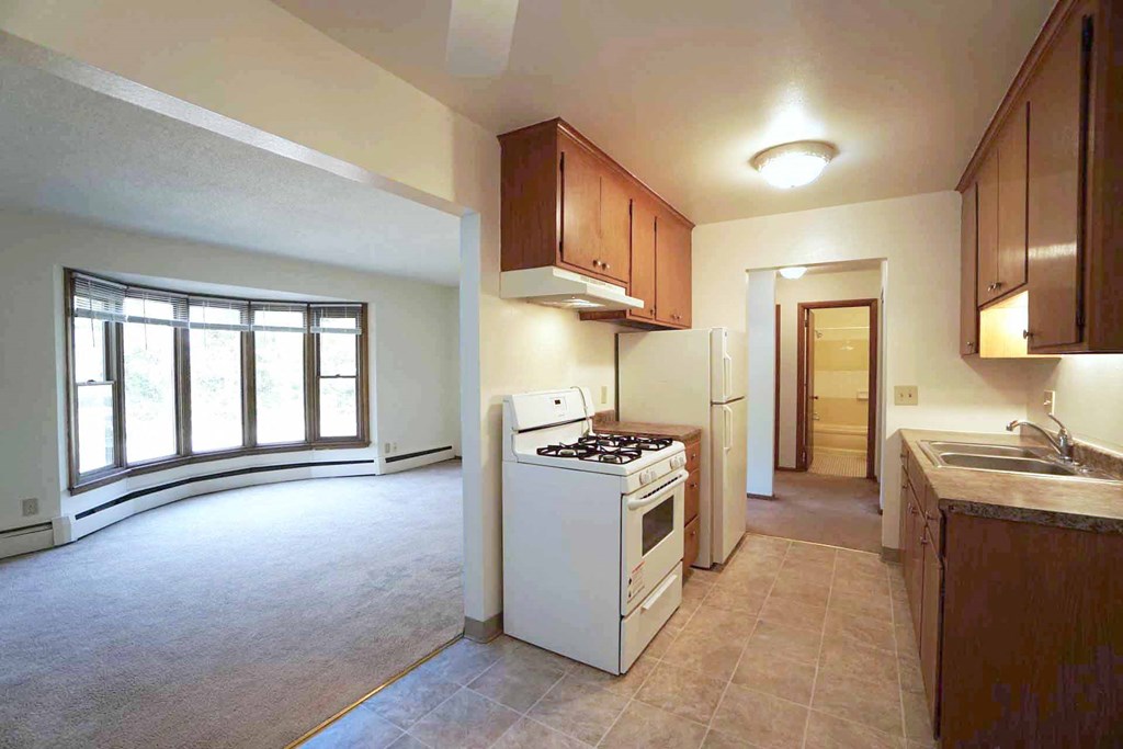 an empty kitchen and living room with a large window