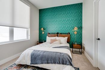 a bedroom with a green accent wall and a bed