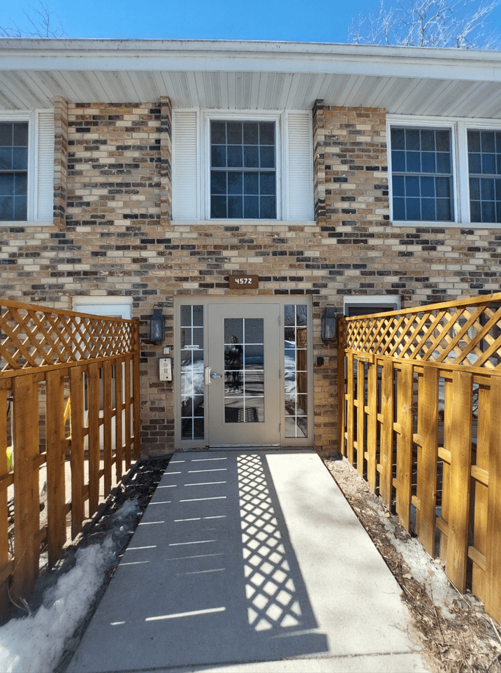 a house with a wooden fence and a white door