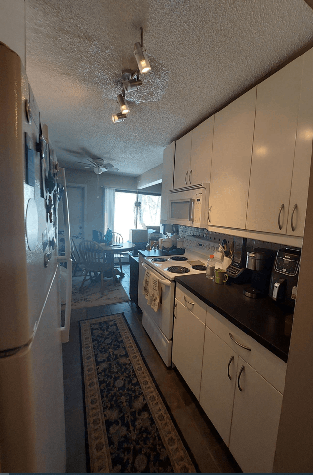 a kitchen with white cabinets and a rug