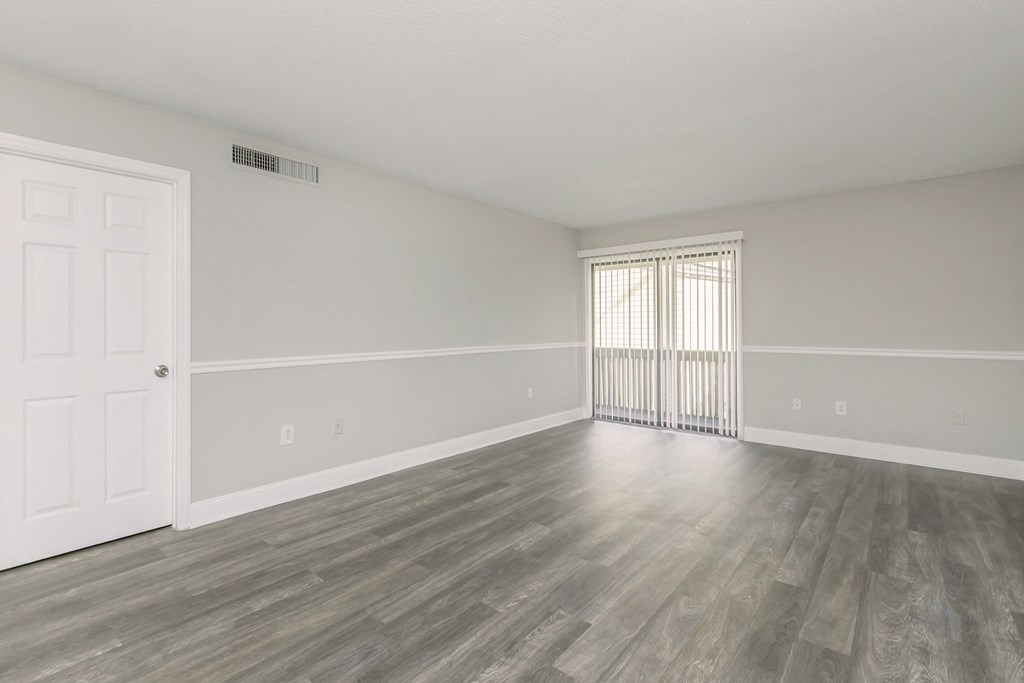 the living room and dining room of an apartment with wood flooring
