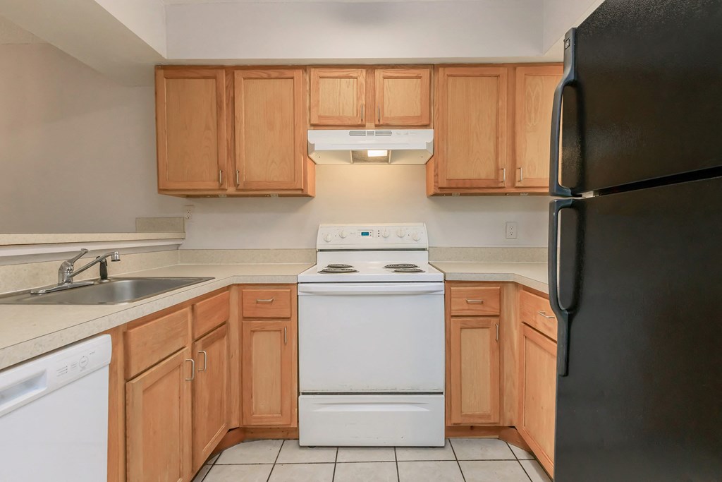 an empty kitchen with a stove refrigerator and sink