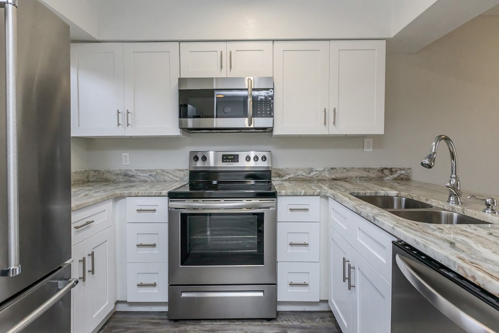 a kitchen with white cabinets and stainless steel appliances